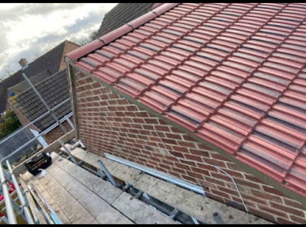 Newly completed tiled roof with ridge tiles on a home in Colchester, Essex